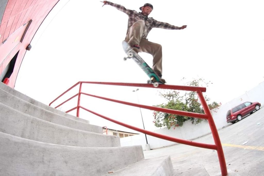 Skateboarder Gerardo Sosa performing a grind on a red rail